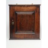 AN OAK SPICE CUPBOARD, 18th century, of oblong form with moulded cornice, shallow base, single