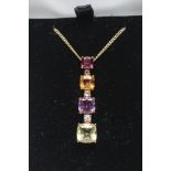 A MULTI GEM PENDANT AND MATCHING DROP STUD EARRINGS, each set with graduating garnet, topaz,