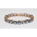 A 'MYSTIC TOPAZ' BRACELET, the nineteen facet cut oval crystals claw set in a 9ct gold frame (Est.