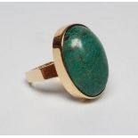 A MODERN DRESS RING, the oval cabochon polished green hardstone collet set to a plain square section