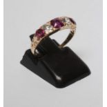 A FIVE STONE RUBY AND DIAMOND RING, the three cushion cut rubies claw set with an old brilliant