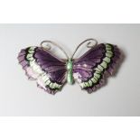 A STERLING SILVER AND ENAMEL BUTTERFLY BROOCH with green and black markings to dark lilac wings