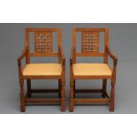 A PAIR OF ROBERT THOMPSON ADZED OAK ELBOW CHAIRS, 1950's, the tapering backs with pierced lattice
