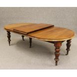 A VICTORIAN MAHOGANY EXTENDING DINING TABLE, the moulded edged D ended top with three separate