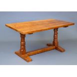 A ROBERT THOMPSON ADZED OAK REFECTORY TABLE, 1950's, of rounded oblong form raised on turned faceted