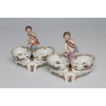 A PAIR OF BERLIN PORCELAIN FIGURAL SALTS, late 19th century, each modelled as a putto standing