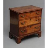 A SMALL MAHOGANY STRAIGHT FRONTED CHEST, the moulded edged top over three drawers with brass drop