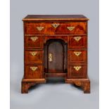 A GEORGE I AND LATER WALNUT KNEEHOLE DESK, the banded quarter veneered top over long frieze