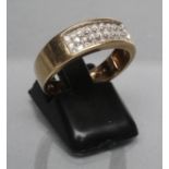 A DIAMOND BAND RING, the wide 9ct gold panel point set with three rows of three small diamonds,