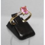 A PINK SAPPHIRE DRESS RING, the emerald cut stone claw set to shoulders each set with two diamond