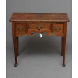A GEORGE III OAK LOW BOY, late 18th century, the moulded edged top with re-entrant corners, scroll
