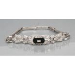 AN ART DECO DIAMOND COCKTAIL BRACELET, the canted oblong panel centred by a polished black onyx