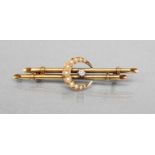 A LATE VICTORIAN DOUBLE BAR BROOCH centred by a small claw set diamond within a seed pearl crescent,