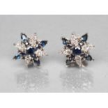A PAIR OF SAPPHIRE AND DIAMOND STAR CLUSTER EAR STUDS, the white posts stamped 750, 18k (Est. plus