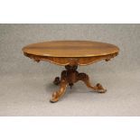 A VICTORIAN ROSEWOOD LOO TABLE, the moulded edged top over scrolled frieze carved with foliage and