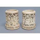 A PAIR OF CHINESE IVORY VASES of cylindrical form, carved and pierced in high relief with figures, 4
