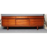 A MID CENTURY DESIGN TEAK LOW SIDEBOARD, the fascia with three frieze drawers, the centre one fitted