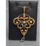 AN EDWARDIAN OPEN PENDANT/BROOCH centred by a collet set facet cut aquamarine and hung with a