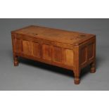 A WILF HUTCHINSON ADZED OAK BLANKET BOX of canted oblong form with cleated hinged lid, panelled