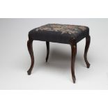 A VICTORIAN ROSEWOOD CARVED DRESSING STOOL of oblong form upholstered with a floral blue ground