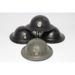 FOUR SECOND WORLD WAR HOME FRONT BRITISH HELMETS, one in green painted G.P.O W, the others in