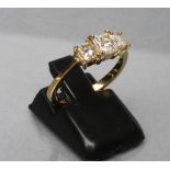 A THREE STONE DIAMOND RING, the square cut stones point set to a plain shank stamped 585, size M (