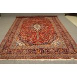 A PERSIAN CARPET, modern, the red field with navy, sky blue and ivory spandrels and central gul