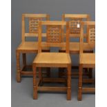 A ROBERT THOMPSON SET OF FOUR OAK DINING CHAIRS, the tapering square back with pierced woven