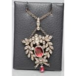 A VICTORIAN DIAMOND PENDANT, the central oval facet cut garnet close back collet set to an open