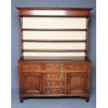 AN OAK ENCLOSED DRESSER, early 19th century, the boarded delft rack with moulded cornice, shaped