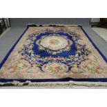 A CHINESE WASHED AND FRINGED CARPET, the Royal blue field with ivory spandrels and central medallion