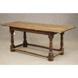 A JOINED OAK DINING TABLE, late 17th century and later, the associated three plank top on moulded