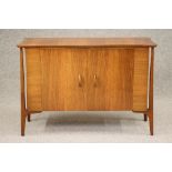 AN EVEREST TEAK SIDEBOARD, 1950, the serpentine top on turned tapering corner supports extending