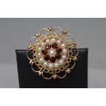 A GARNET AND PEARL FLOWERHEAD PENDANT/BROOCH, stamped 9ct, ZEET(?) (Est. plus 21% premium inc. VAT)