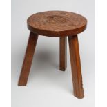 AN ADZED OAK STOOL by Thomas Whitaker of Littlebeck, the circular seat with central carved Yorkshire