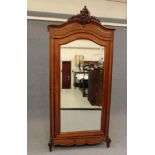 A MAHOGANY ARMOIRE, 19th century, the arched moulded cornice centred by a carved scrolling foliate