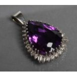 AN AMETHYST AND DIAMOND PENDANT, the pear cut amethyst claw set to a border of small brilliants