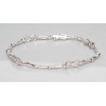 A DIAMOND BRACELET with four open scroll links tied by eliptical panels all pave set with small