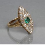 AN EMERALD AND DIAMOND DRESS RING, the central cushion cut emerald set to a marquise shaped plaque