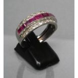 A RUBY AND DIAMOND HALF HOOP RING, the ten graduated calibre cut rubies channel set to a border of