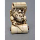 A JAPANESE IVORY NETSUKE, Meiji period, of Shoki emerging from a scroll, unsigned, attributed to