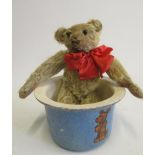 An early 20th century teddy bear, with straw filling, black button eyes, remnants of sewn nose,