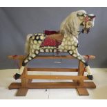 A carved wood rocking horse in dappled grey, with turning head, painted eyes, open mouth, horse hair