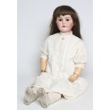 A Kammer & Reinhardt bisque socket head doll, with brown glass sleeping eyes, open mouth and