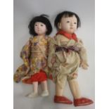 Two Japanese composition head dolls, with glass eyes, closed mouths, composition and cloth bodies,