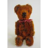 A rare pre-war dark orange Schuco teddy, sewn nose and mouth, one pin eye, and rotating neck and