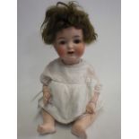 A Cuno & Otto Dressel bisque socket head doll, with brown glass sleeping eyes, open mouth, teeth and