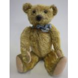 An old teddy bear, with black button eyes, rotating neck, shoulder and hip joints, sewn nose and
