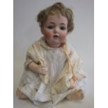 A Kammer & Reinhardt bisque socket head doll, with blue glass sleeping eyes, open mouth, teeth,