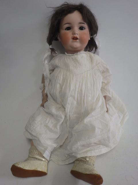 An Armand Marseille bisque socket head doll, with grey glass sleeping eyes, open mouth, teeth and
